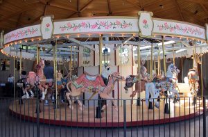 The Rose Carousel at The Butchart Gardens, with a variety of animals. In the foreground is a camel.