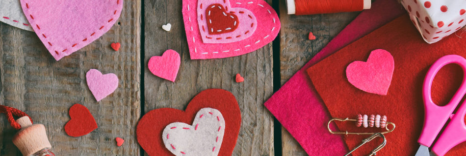 A collage of pink and red craft materials: felt, thread, and scissors
