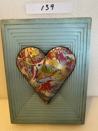 A light green-blue memory block with a multicoloured heart mounted on it