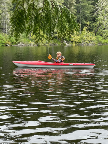 A child is kayaking on a lake